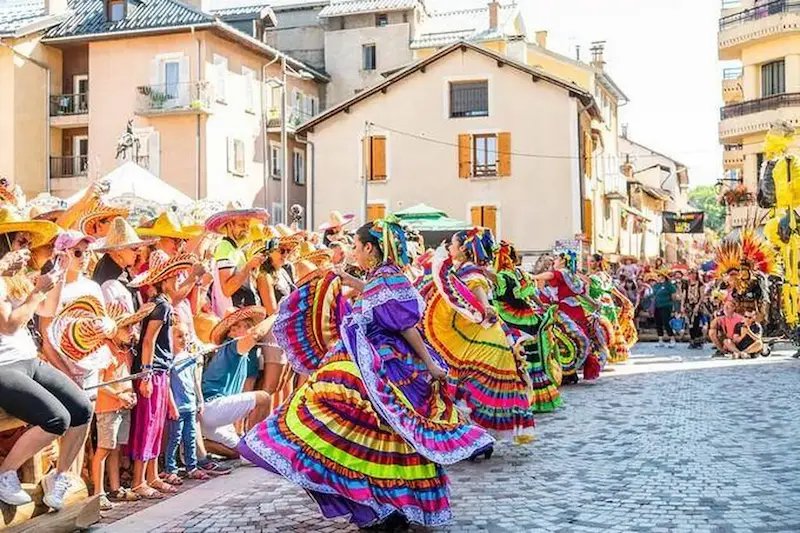 Danseuses en robes colorées dans une rue de Barcelonnette pendant les Fêtes Latino-Mexicaines